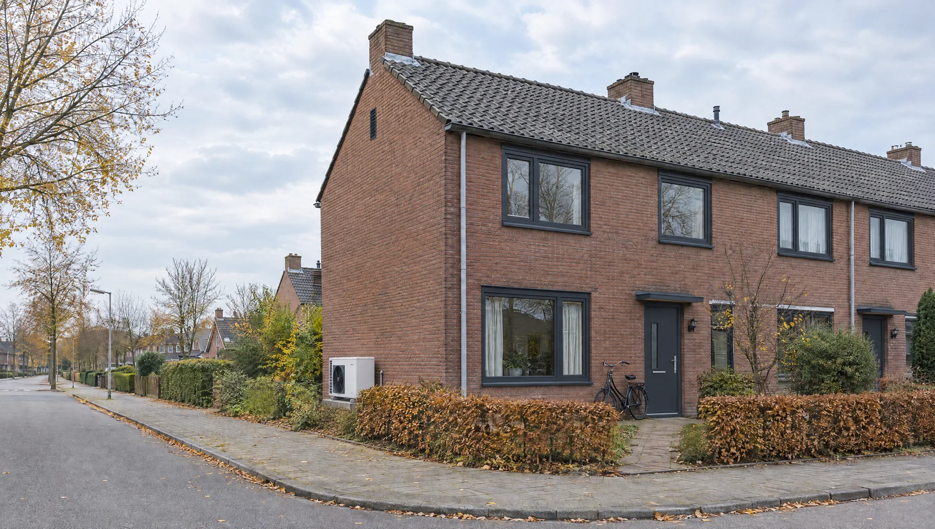 De hoekwoning met nieuwe antracietkleurige kozijnen, HR++-glas en een hybride warmtepomp tegen de zijgevel
